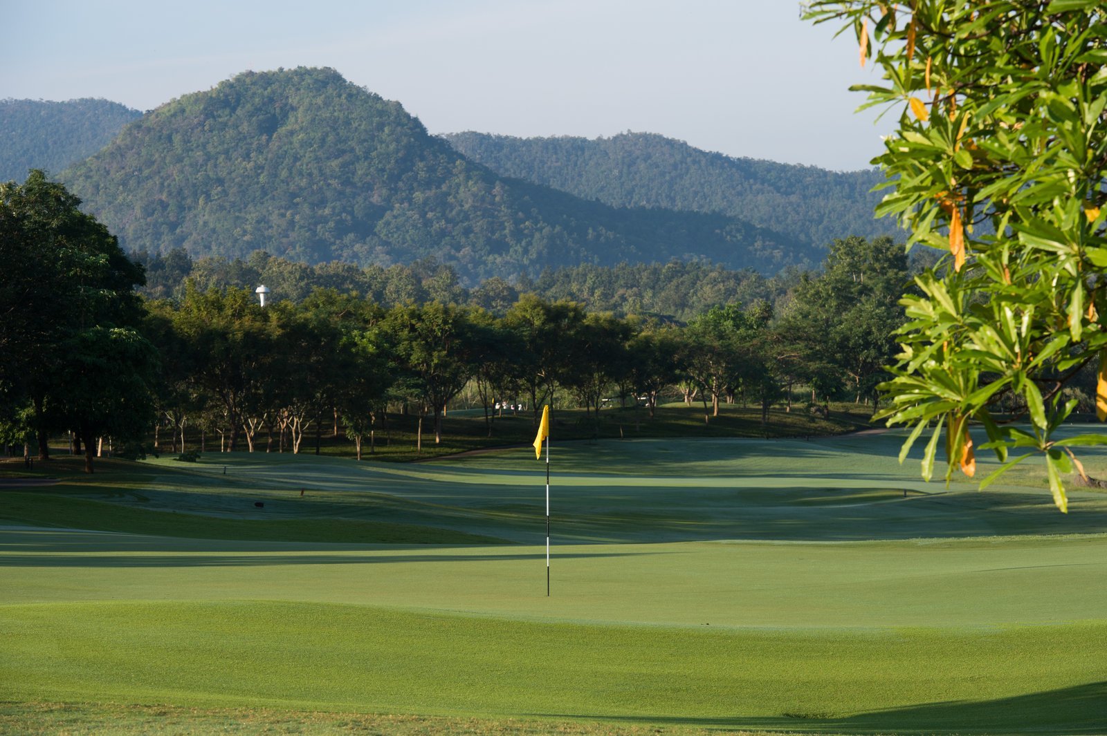 The 9th green at Chiangmai Highlands under a mountain backdrop
